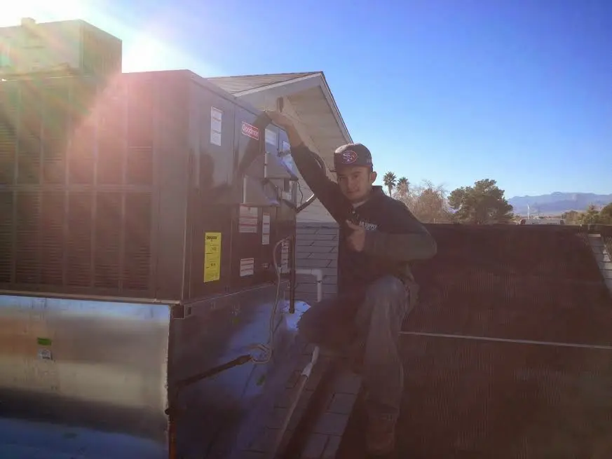 HVAC technician performing AC Tune-Up on a rooftop unit in Mango
